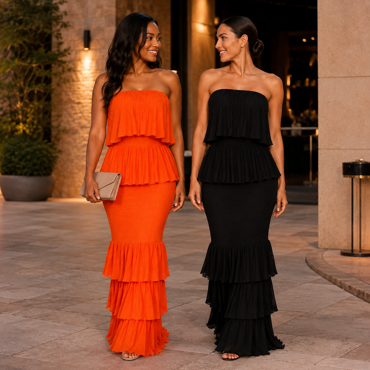 Two friends wearing orange and black Rayna Ruffle Maxi Dresses